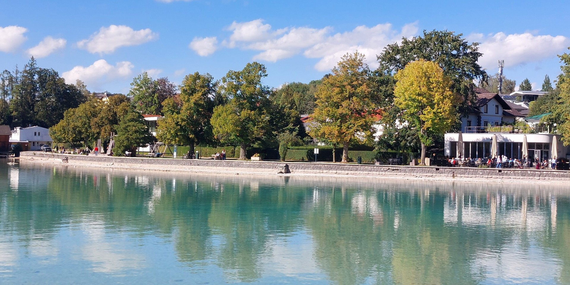 Seeblick mit Promenade und Bäumen im Herbst, Villen am Ufer, Wörthersee